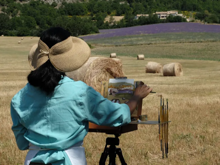 A painter working among hay bales and lavender fields