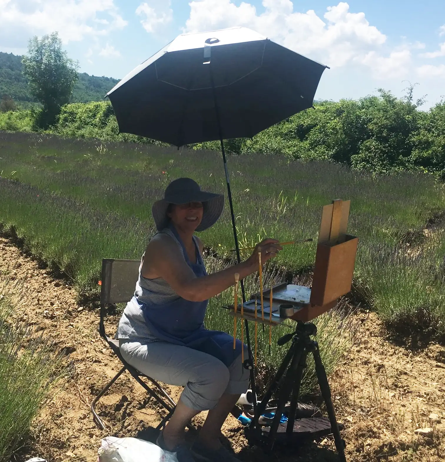 A complete plein-air painting kit arranged outdoors